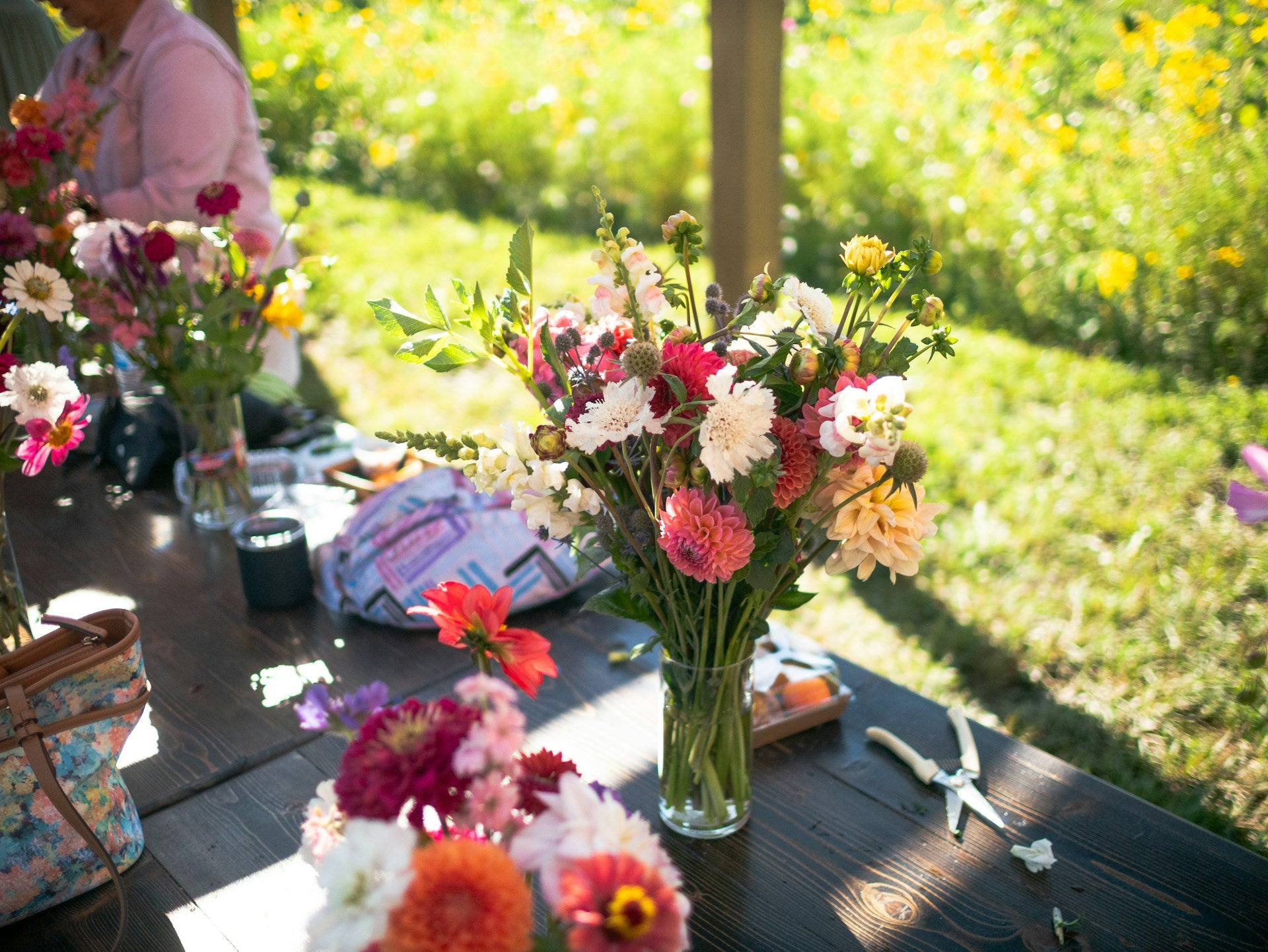 Bouquets of flowers on a wooden table with a grassy background